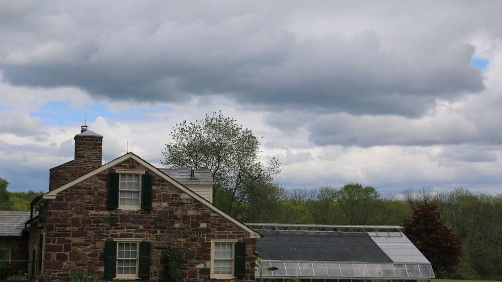 A greenhouse standing on a lawn in a home garden